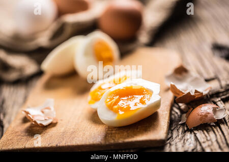 Close-up bouillie ou oeufs de poulet crues sur planche de bois. Banque D'Images