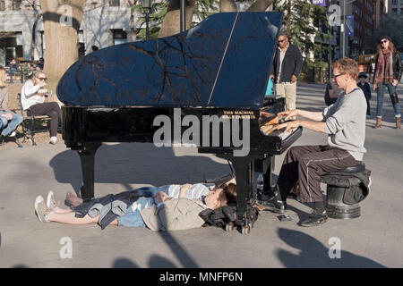 Un musicien ambulant avec l'exécution de 2 personnes se trouvant sous son mystérieusement grand piano. Dans la région de Washington Square Park à Manhattan, New York City. Banque D'Images