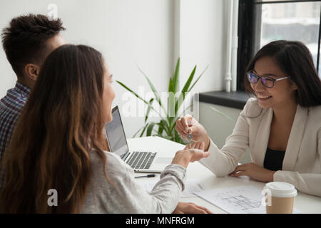 Agent immobilier femelle donnant clefs pour l'heureux couple Banque D'Images