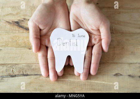 Rendez-vous chez le dentiste, coupures forme des dents écrire le mot que dentiste et date dans la main femme Banque D'Images