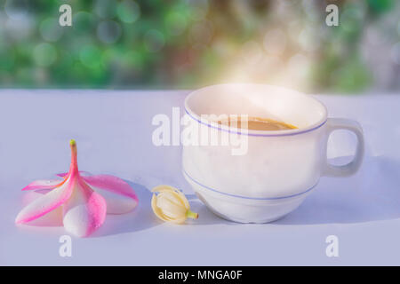 Abstract soft floue et soft focus une tasse de café avec le frangipanier, Plumeria, Michelia alba, Magnolia, fleurs, le bokeh, feux de croisement, lens flar Banque D'Images