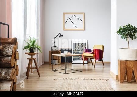 Conception simple en bois en plan ouvert, lumineux séjour avec fauteuil d'intérieur et de l'affiche minimaliste, bois de chauffage Banque D'Images