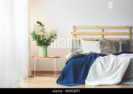 Lit et bouquet de fleurs en chambre à coucher confortable intérieur créatif Banque D'Images