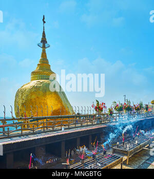 La vue sur la Pagode Kyaiktiyo Golden Rock ou de l'autel avec des offrandes de fleurs, de bougies et d'encens, Kyite Htee Yoe Mount, Myanmar. Banque D'Images