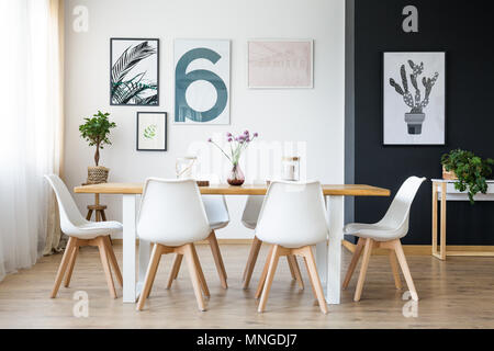 Set de table en bois avec chaises blanches dans cette chambre confortable Banque D'Images