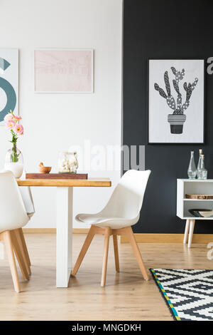 Chaise blanche placés par la table en bois dans la salle à manger Banque D'Images