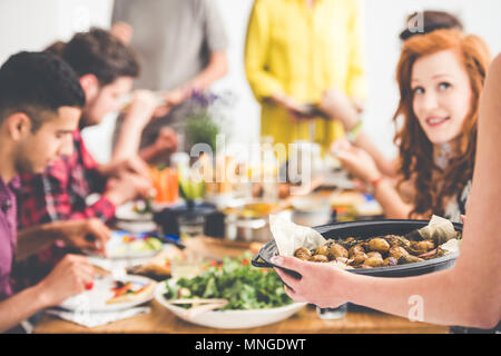 Actions végétarien végétalien pommes de terre cuites au four avec des amis pendant la réunion à la maison vege Banque D'Images