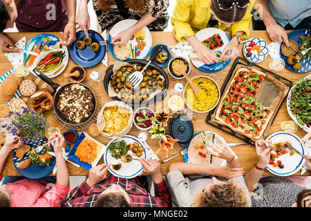 Réunion d'amis au Veggie table commune dans le avec des aliments sains Banque D'Images