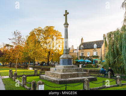 Croix de Pierre War Memorial dans le joli village de Bourton On The Water dans les Cotswolds, Gloucestershire avec arbres en couleurs d'automne Banque D'Images