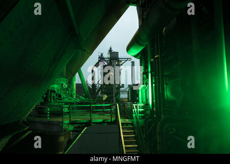 Vue de nuit sur une usine d'acier historique à Duisburg, en Allemagne, avec un témoin vert, brillant sur le côté, à l'avant-plan Banque D'Images