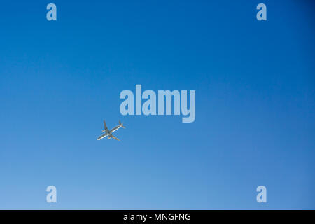 Avion de passagers au-dessus des mouches sur fond de ciel bleu clair sans nuages. Vue de dessous Banque D'Images