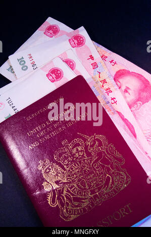 Un UK/passeport européen et Chinois 100 Yuan billets de banque qui offrent l'image de Mao Zedong. Banque D'Images