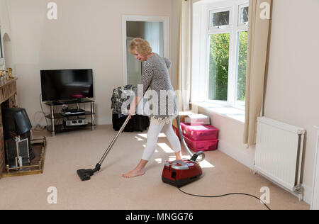 Déménagement, femme à l'aide d'un aspirateur pour aspirateur très hoover le tapis avant de déménager hors de la propriété. Banque D'Images