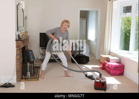 Déménagement, femme à l'aide d'un aspirateur pour aspirateur très hoover le tapis avant de déménager hors de la propriété. Banque D'Images