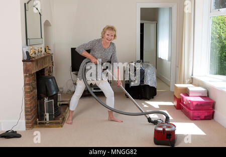 Déménagement, femme à l'aide d'un aspirateur pour aspirateur très hoover le tapis avant de déménager hors de la propriété. Banque D'Images