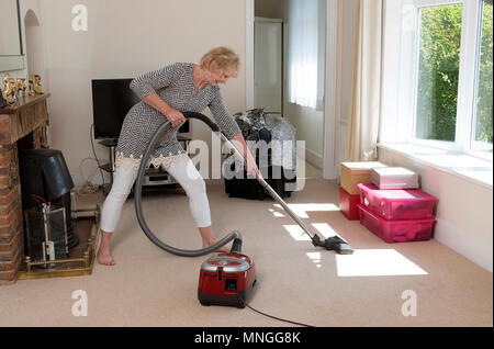 Déménagement, femme à l'aide d'un aspirateur pour aspirateur très hoover le tapis avant de déménager hors de la propriété. Banque D'Images