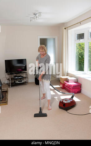 Déménagement, femme à l'aide d'un aspirateur pour aspirateur très hoover le tapis avant de déménager hors de la propriété. Banque D'Images