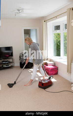 Déménagement, femme à l'aide d'un aspirateur pour aspirateur très hoover le tapis avant de déménager hors de la propriété. Banque D'Images