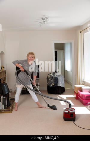 Déménagement, femme à l'aide d'un aspirateur pour aspirateur très hoover le tapis avant de déménager hors de la propriété. Banque D'Images