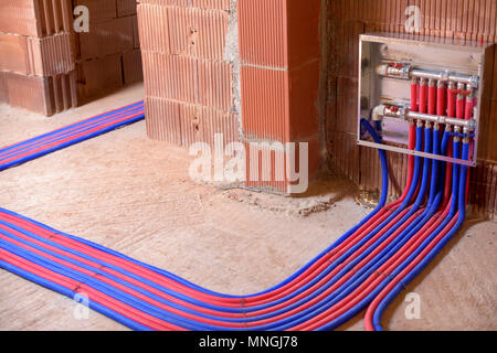 Les tuyaux de plancher en deux couleurs, rouge et bleu, et le panneau de commande. Banque D'Images