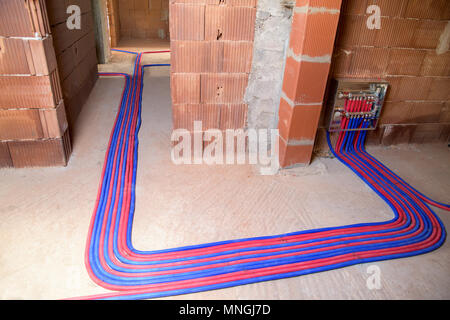 Chauffage par le sol, d'installation des tuyaux rouge et bleu et le panneau de commande. Banque D'Images