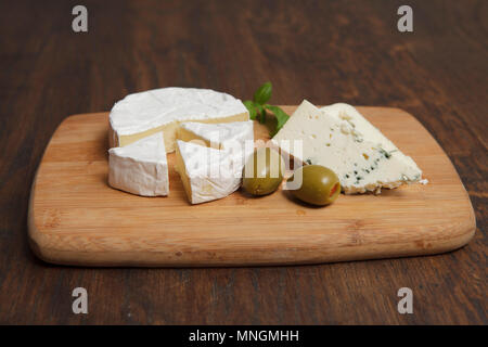 Morceaux de deux sortes de fromages français sur planche de bois Banque D'Images