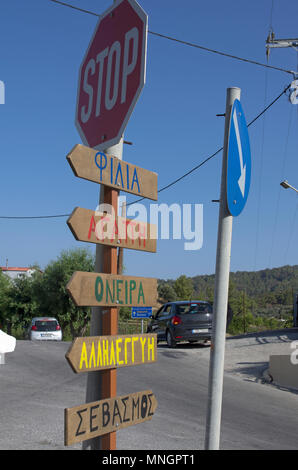 Panneau routier avec des noms de villes de la langue grecque et le sens de la circulation sur l'île de Rhodes et de panneau d'arrêt (Grèce). Banque D'Images