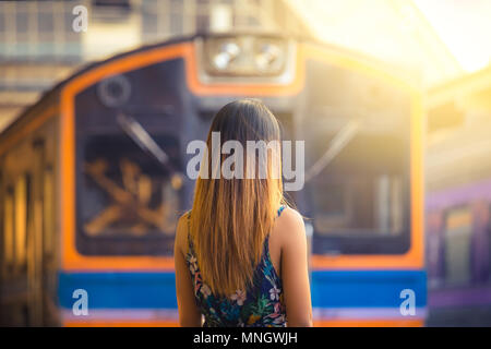 Woman traveler avec hat près des voies de chemin de fer en attente de train Banque D'Images