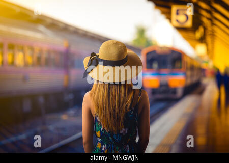 Woman traveler avec hat près des voies de chemin de fer en attente de train Banque D'Images