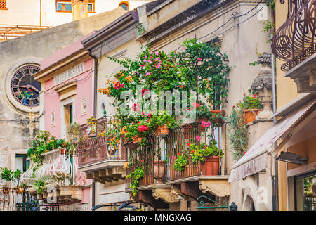 Balcon avec pots de fleurs rouge et vert feuillage en Toarmina, Sicile, Italie Banque D'Images