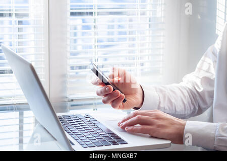 Businessman travaillant avec un ordinateur portable et smartphone in bright office financier, comptable, conseiller en investissement d'entreprise Banque D'Images