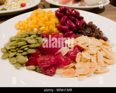 Pile de la machine à vapeur du maïs jaune, haricots rouges, graines de tournesol, amandes, raisins secs, doux et jujube salade et des aliments sains Banque D'Images