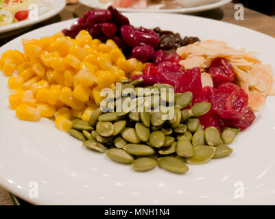 Pile de la machine à vapeur du maïs jaune, haricots rouges, graines de tournesol, amandes, raisins secs, doux et jujube salade et des aliments sains Banque D'Images