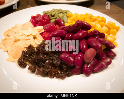 Pile de la machine à vapeur du maïs jaune, haricots rouges, graines de tournesol, amandes, raisins secs, doux et jujube salade et des aliments sains Banque D'Images