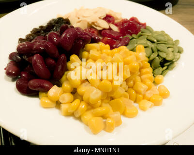 Pile de la machine à vapeur du maïs jaune, haricots rouges, graines de tournesol, amandes, raisins secs, doux et jujube salade et des aliments sains Banque D'Images