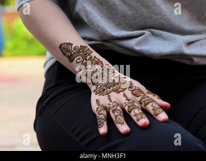 Coller Mehndi séchant sur a woman's hand, appliquée par un artiste à l'henné Shilparamam arts and crafts village, Hyderabad, Inde. La promotion de l'art de la diversité. Banque D'Images