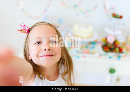 Adorable petite fille princesse avec couronne à kids Birthday party décisions selfies Banque D'Images