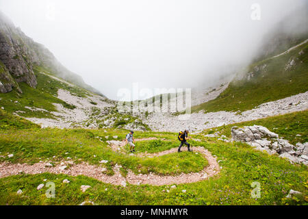 Deux randonneurs marchent sur des sentiers sinueux près du Mont Krn dans les Alpes Juliennes, en Slovénie Banque D'Images