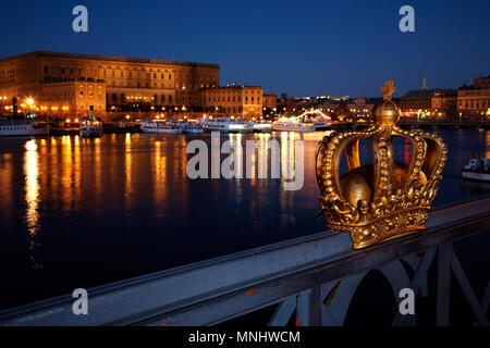 Stockholm, Suède - le 9 novembre 2012 : la couronne royale sur la rambarde du pont de Skeppsholmen, le palais royal en arrière-plan. Banque D'Images