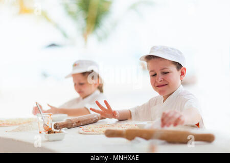 Adorable petite fille et garçon mignon habillé comme chefs pizza Banque D'Images