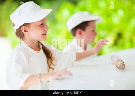 Adorable petite fille et garçon mignon habillé comme chefs pizza Banque D'Images