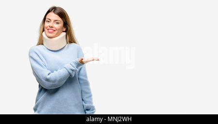 Jeune femme blessée wearing neck brace collar tenant quelque chose dans la main vide Banque D'Images