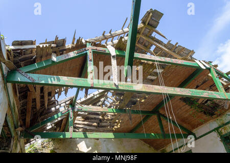 L'école du village à l'abandon et de l'effondrement du toit bois maison ouverte à lentement les éléments météorologiques. Banque D'Images