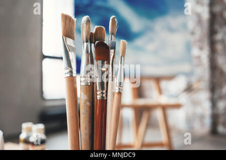 Pinceaux de l'artiste gros plan sur fond flou de l'atelier du peintre. Différentes brosses pour l'établissement studio intérieur. Concept créatif Banque D'Images