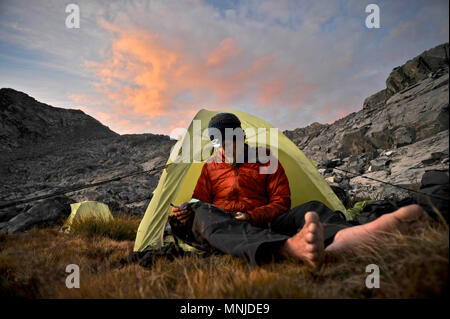 Backpackers utiliser les projecteurs au camp près de Mt Ritter lors d'un trek de la Sierra en Haute Route Minarets Wilderness, Inyo National Forest, Californie, USA Banque D'Images