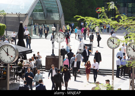 Canary Wharf, horloges indiquent le moment juste avant 12h à l'extérieur de la station de métro avec les employés autour de la mouture le soleil brille, Banque D'Images