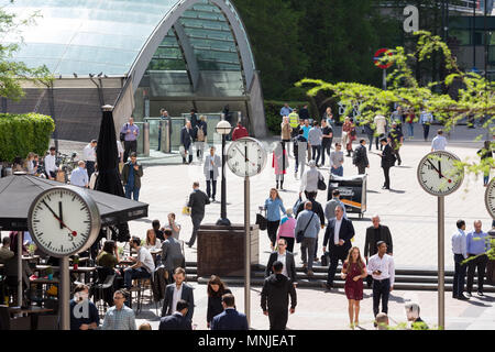 Canary Wharf, horloges indiquent le moment juste avant 12h à l'extérieur de la station de métro avec les employés autour de la mouture le soleil brille, Banque D'Images