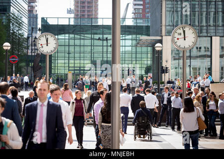 Canary Wharf, horloges indiquent le moment juste avant 12h à l'extérieur de la station de métro avec les employés autour de la mouture le soleil brille, Banque D'Images