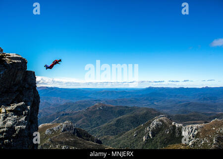 Cavalier de base pendant la chute libre contre ciel bleu clair à droite après de sauter du haut de la Frenchman's Cap, Tasmanie, Australie Banque D'Images