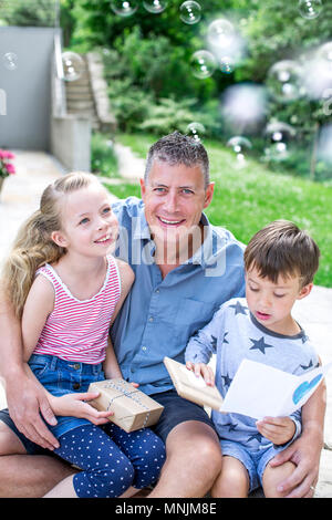 La fête des Pères - les enfants de donner des cadeaux à leur père smiling Banque D'Images